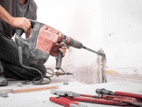 Bauarbeiter mit Hilti-Stemmeisen auf der Baustelle