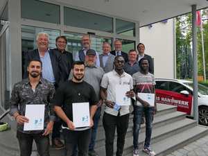 Große Freude über die Zeugnisse: Ahmar Kengo, Taufik Moufak, Musa Swaray und Salimo Manneh (vorne von links) haben im Einstiegsjahr vom Projekt 2+ sehr viel gelernt. Unterstützung kommt von den Betrieben, der Agentur für Arbeit, dem BZTG und der Handwerkskammer. Hinter den Teilnehmern sind zu sehen (v.li.): Mathias Suhr, Jann Onneken, Rainer Beermann (unten), Heiko Henke (oben), Heiko Posegga, Gert Mora Motta, Eduard Drefs und Kai Vensler.