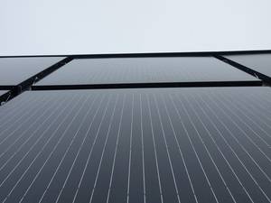 Nahaufnahme der installierten Photovoltaikelemente. Sie ersetzen die Wärmedämmung einer Fassade.
